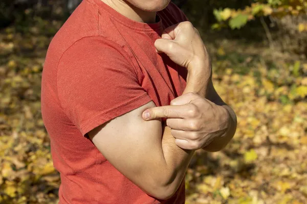 Férfi Megmutatja Erejét Bicepszét Egy Férfi Piros Pólóban — Stock Fotó