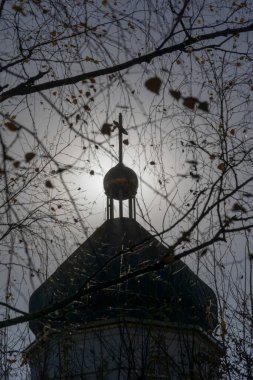 Güneşli bir günde kilisenin çatısının silueti ve haç.