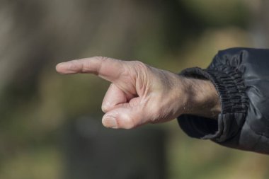 Bir şeye işaret eden ve dikkat çeken işaret parmağı. Yaşlı adamın eli.
