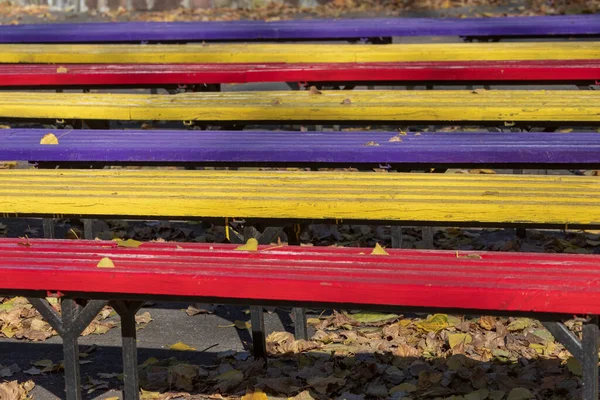 夏日电影院附近公园里的彩色木制长椅 — 图库照片
