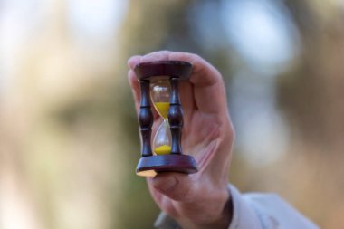 Hayatın kısa olduğunu anlayan yaşlı bir adamın elinde kum saati.