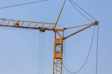 Mavi gökyüzünün arka planında sarı metal üreticisi vinç