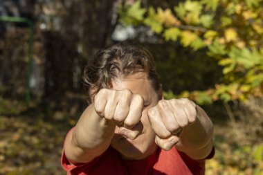 Adam yumruklarını gösteriyor ve soygunculardan korunmak için dövüşüyor.