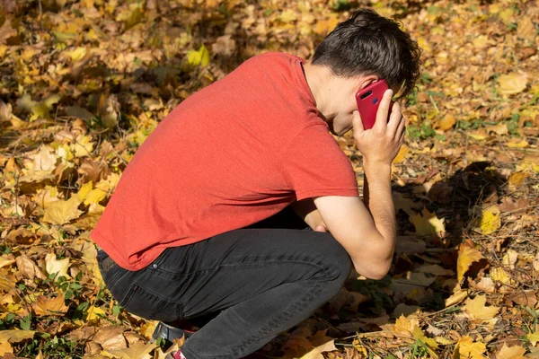 Adamın elinde bir telefon var ve çaresiz ve üzgün.