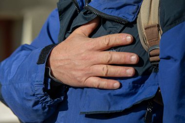 Bir adam sokaktaki bir şeyi işaret eder.