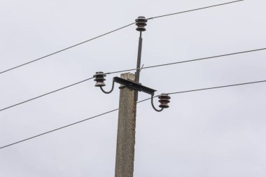 Elektrik hatları gökyüzünün arka planında bir direkte