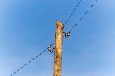 Elektrik hatları gökyüzünün arka planında bir direkte