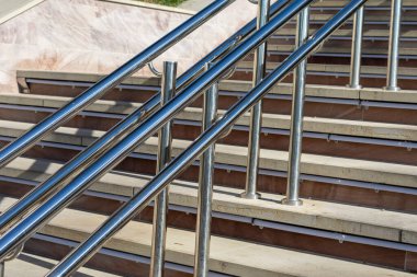 Parlak metal parmaklıklar ve parktaki merdivenler.