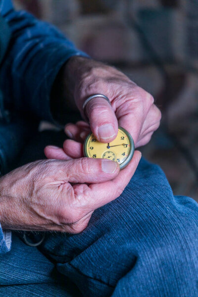Мужчина держит старинные карманные часы. Символ прошедшего времени