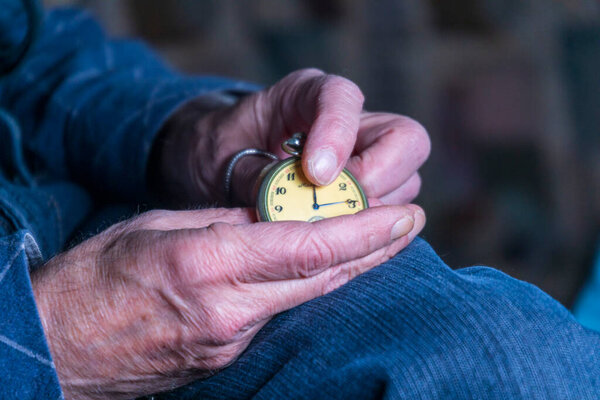 Мужчина держит старинные карманные часы. Символ прошедшего времени