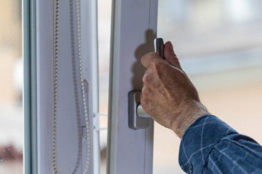 Adam pencereyi açar, böylece odada temiz hava olur.