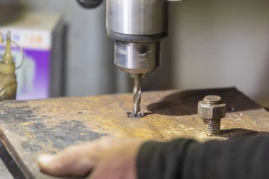 Delme makinesi çalışıyor. Usta atölyede atölye çalışması yapar.