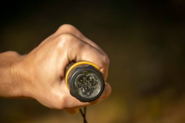 Adamın elinde siyah bir fener var.