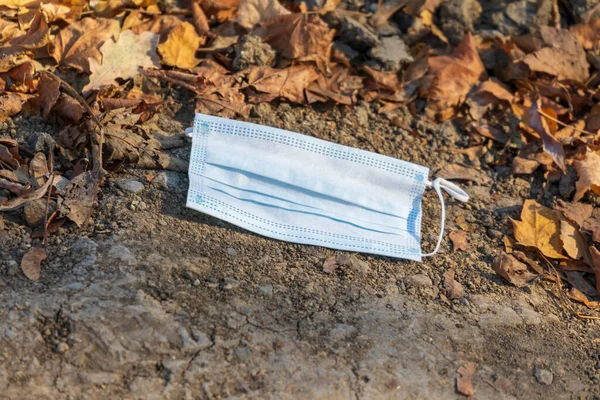 Enfeksiyonlara karşı mavi koruyucu maske yerde yatıyor.