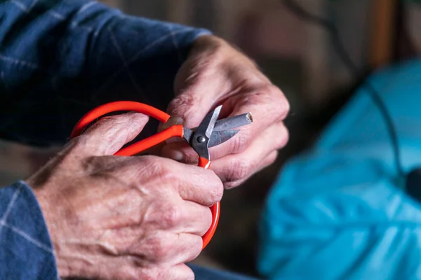 A man holds scissors and a cigarette in his hand, he tries to cut it to quit smoking