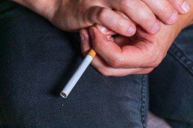 Adam elinde bir sigara tutuyor ve onu yakmaya gidiyor. Kötü alışkanlık - sigara