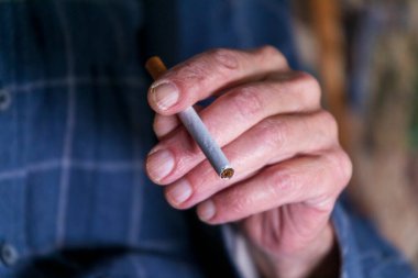 Adam elinde bir sigara tutuyor ve onu yakmaya gidiyor. Kötü alışkanlık - sigara