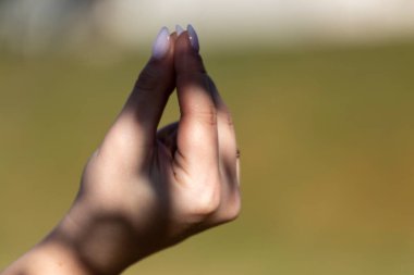 Kız elleriyle duygusal bir jesti parçalıyor.