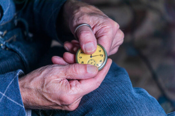 Мужчина держит старинные карманные часы. Символ прошедшего времени