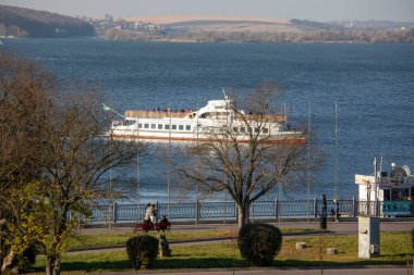 Güz parkının yakınındaki gölde bir turist teknesi.