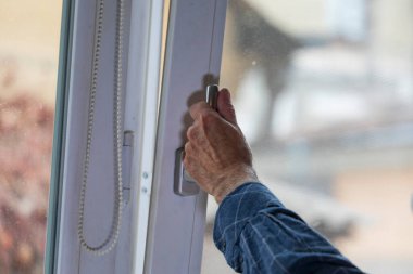 Adam pencereyi açar, böylece odada temiz hava olur.