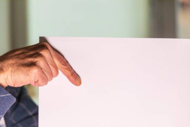 Elinde beyaz bir sayfa kağıt tutan bir adam. Beyaz kağıda metin yazmak için şablon