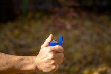 Adamın elinde çakmak var ve sigara içmeye gidiyor.