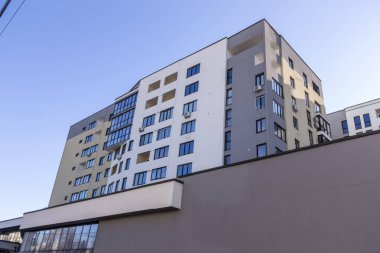 Birçok penceresi olan beyaz-gri bir evin cephesi