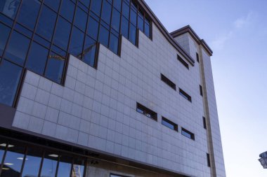 Birçok penceresi olan beyaz-gri bir evin cephesi