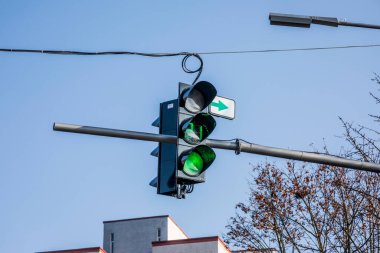 Mavi gökyüzünün arka planında üç renkli trafik ışığı