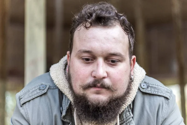 Sakallı bir gencin bir şeyler düşünen portresi.