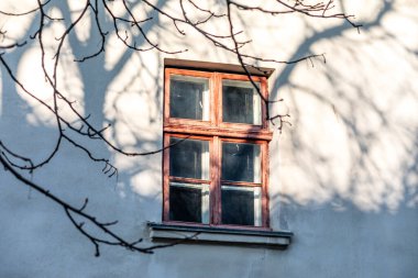 Eski ahşap pencere ve manastırın gri duvarı