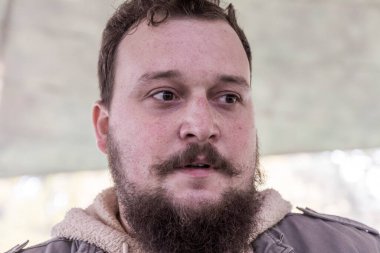 Sakallı ve bıyıklı genç bir adamın kafası karışıktır ve kendini güvensiz hisseder. Adam bir şeyler düşünmüş.