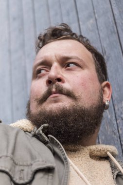 Sakallı ve bıyıklı bir gencin portresi.