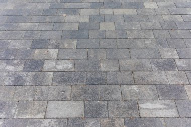 Dikdörtgen şeklindeki gri eski kaldırım taşlarının dokusu. Yerdeki asfalt
