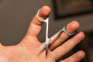 Elinde küçük metal manikür makası