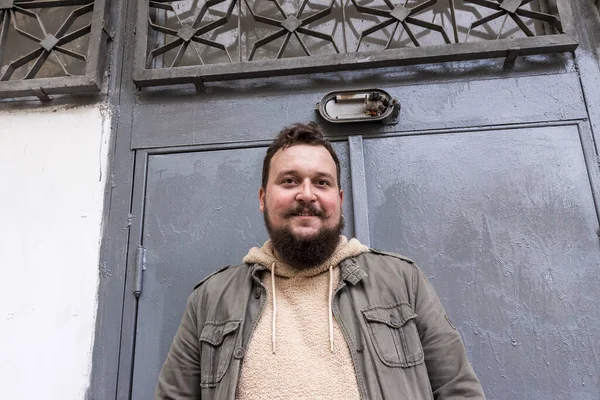 Sakallı ve bıyıklı bir gencin portresi.