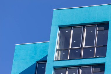 Şehirdeki bir evin ön cephesinde çok pencere var.