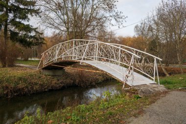 Parktaki nehrin üzerindeki yarı dairesel ahşap köprü.