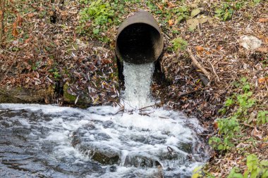 Parktaki su akışı metal bir borudan geliyor.