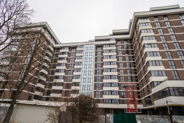 Büyük bir apartmanın ön cephesi. Pencereler ve balkonlar