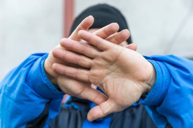 Adam yüzünü elleriyle kapatıyor ki fotoğrafı çekilmesin.