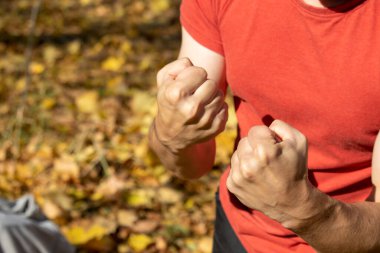 Adam yumruklarını gösteriyor ve soygunculardan korunmak için dövüşüyor.