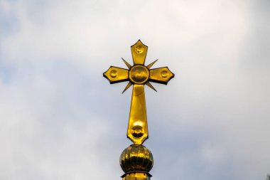 Sarı Hıristiyan haçı kilise ve gökyüzü arka planında