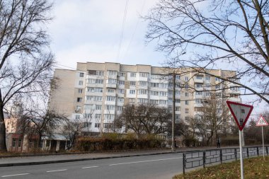 Beyaz tuğladan yapılmış çok katlı bir bina. Evin ön cephesi ve yol tabelası