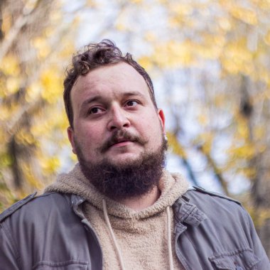 Sakallı ve bıyıklı bir gencin portresi.