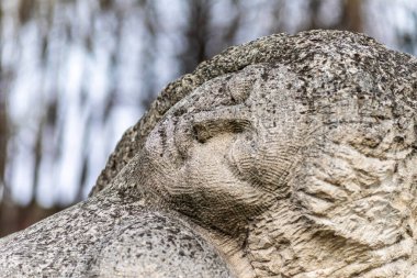 Parkta uzun saçlı bir kadının taş heykeli.