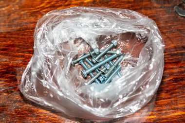 Masadaki bir pakette cıvatalar ve fındıklar