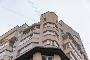 Uzun sarı bir evin cephesi. Pencereler ve balkonlar