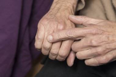 Yaşlı adam parmağının alyansın olması gereken yeri işaret ediyor.